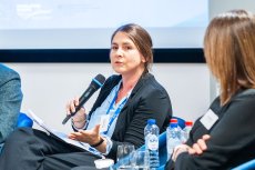 Woman on stage speaking with microphone