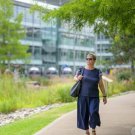 Woman walking in a park near office buildings