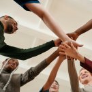 People putting their hands together in support