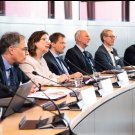 People at a conference table, women speaking
