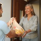 Older person receives a shopping bag at the door