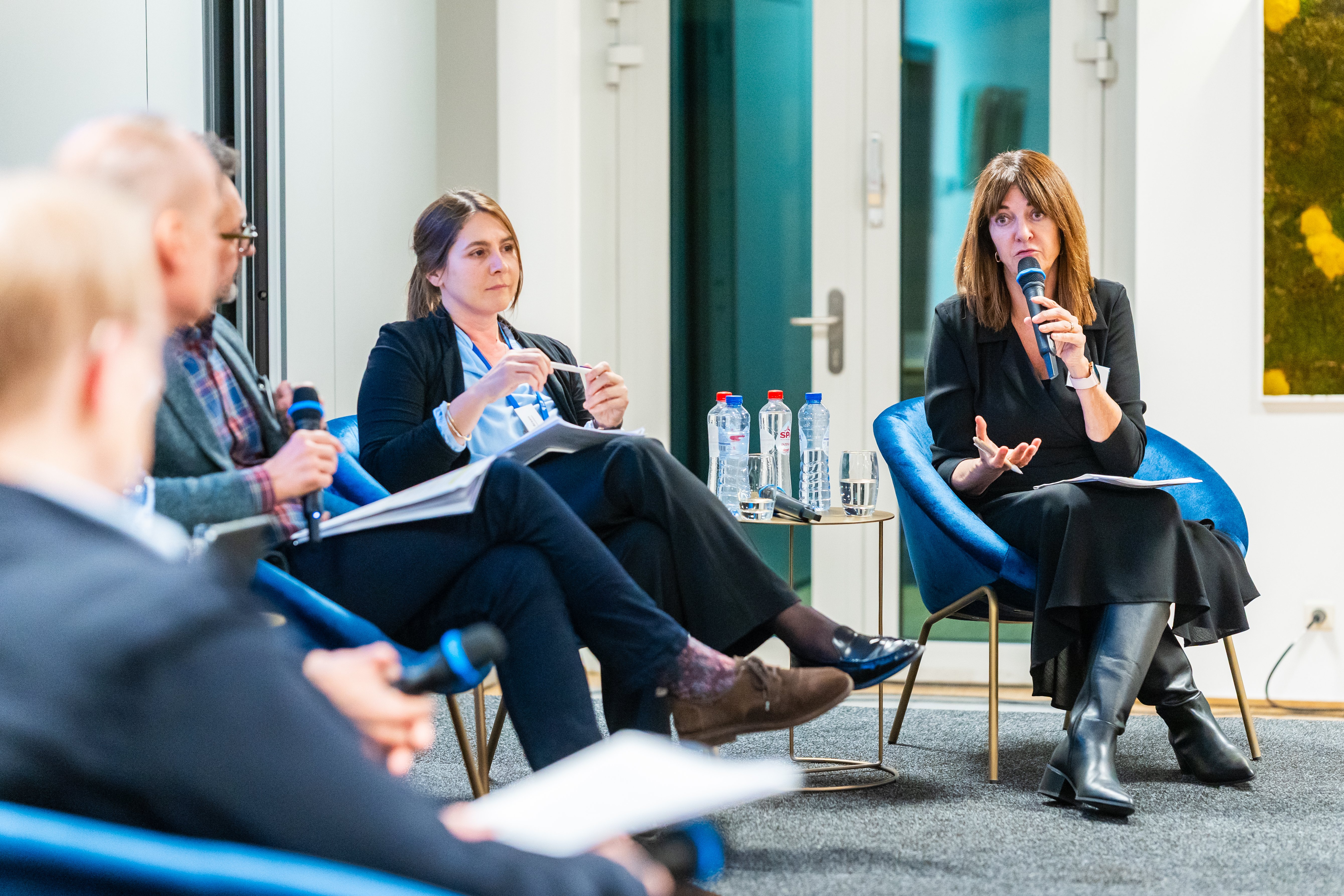 Woman on a stage speaking with microphone
