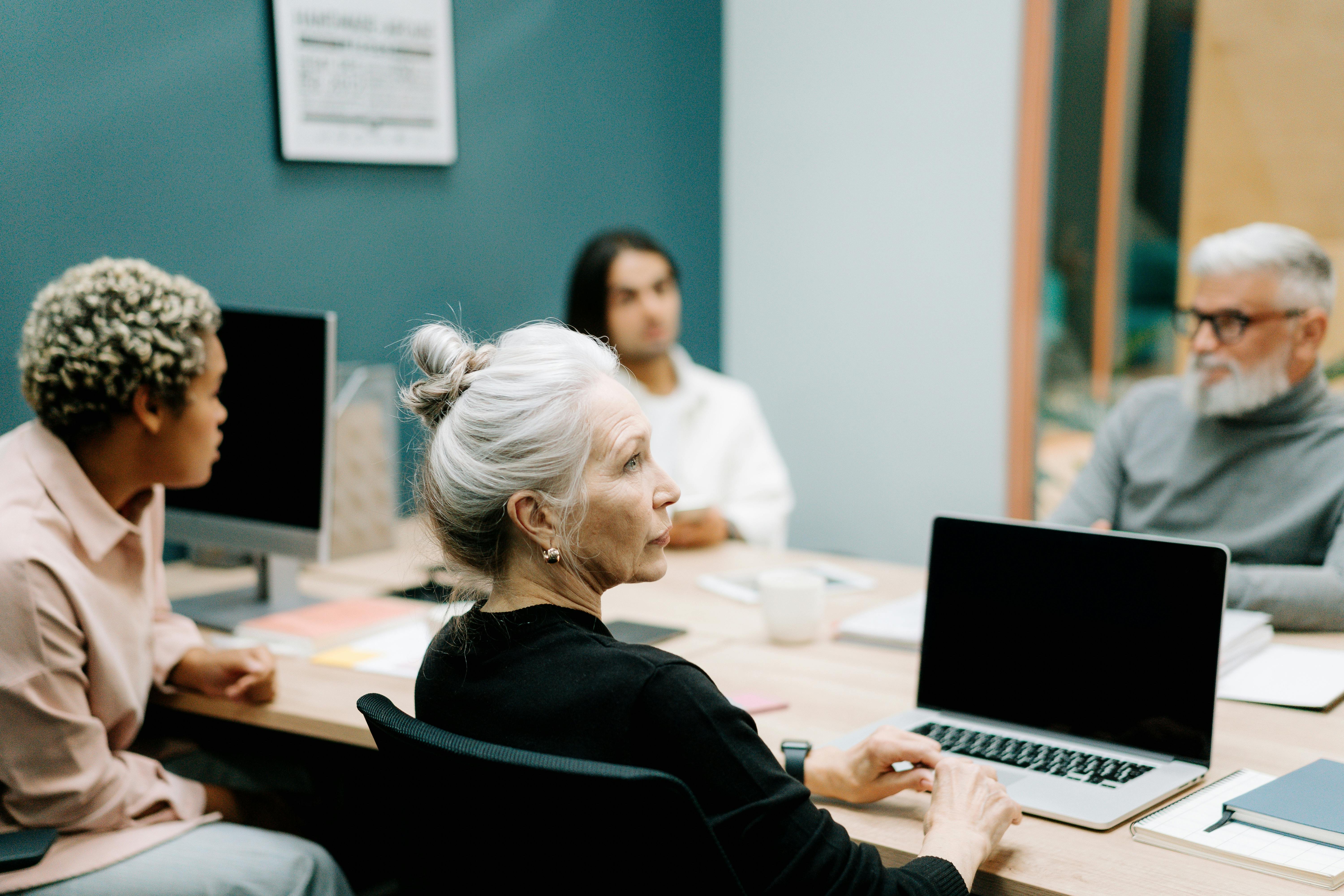 People of various ages sit around a conference table