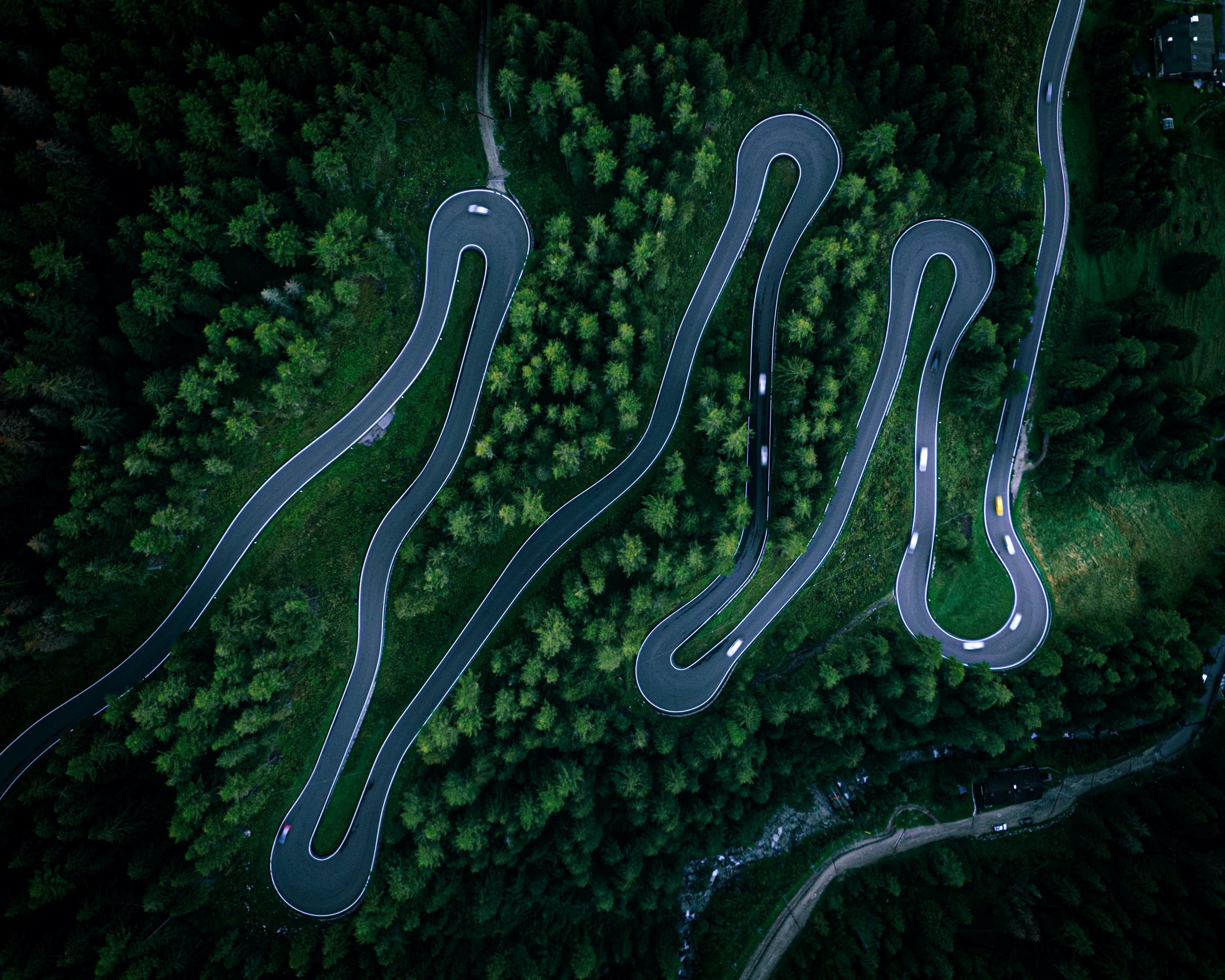 A winding road in green mountains seen from above