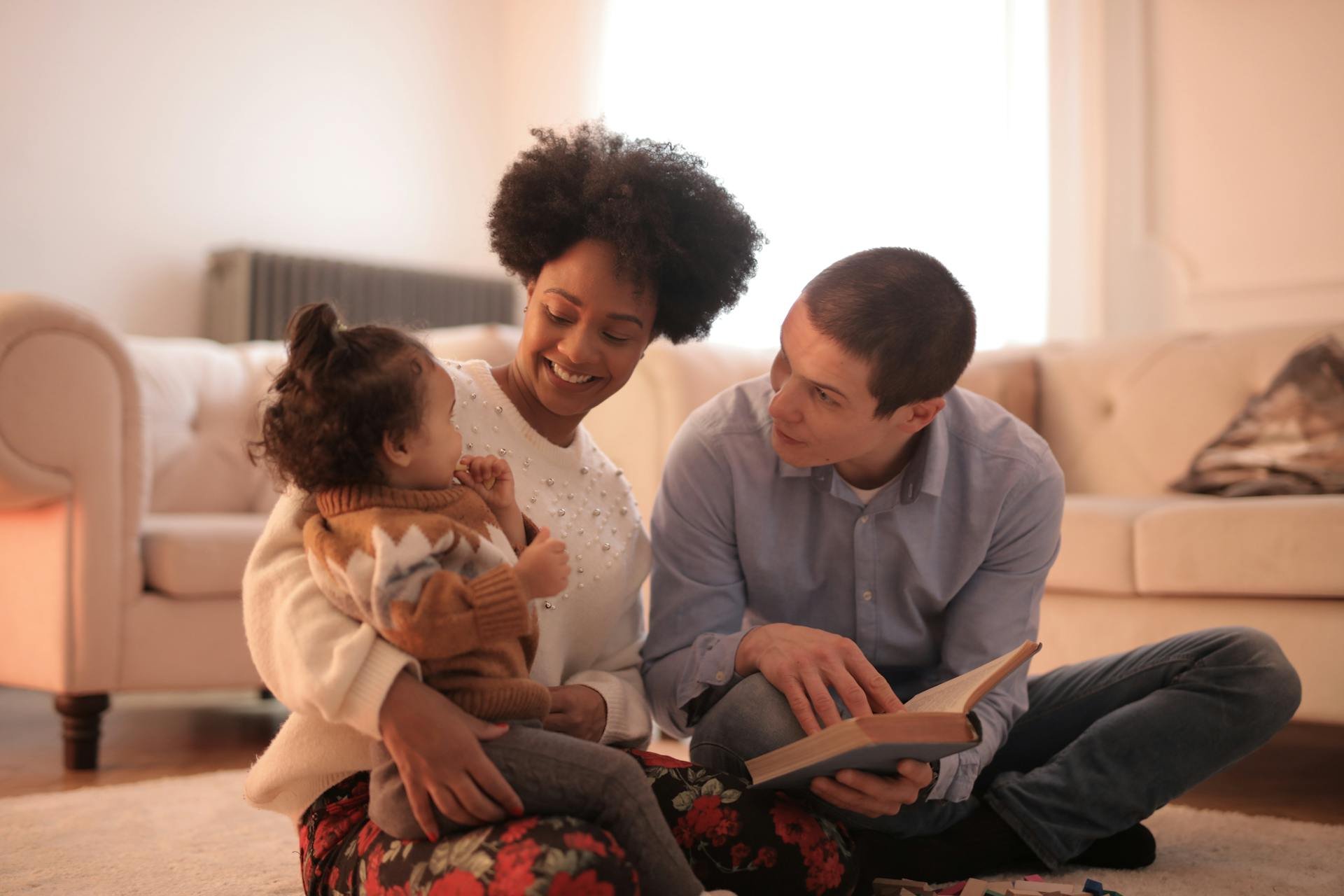 Parents with small child looking at a book together