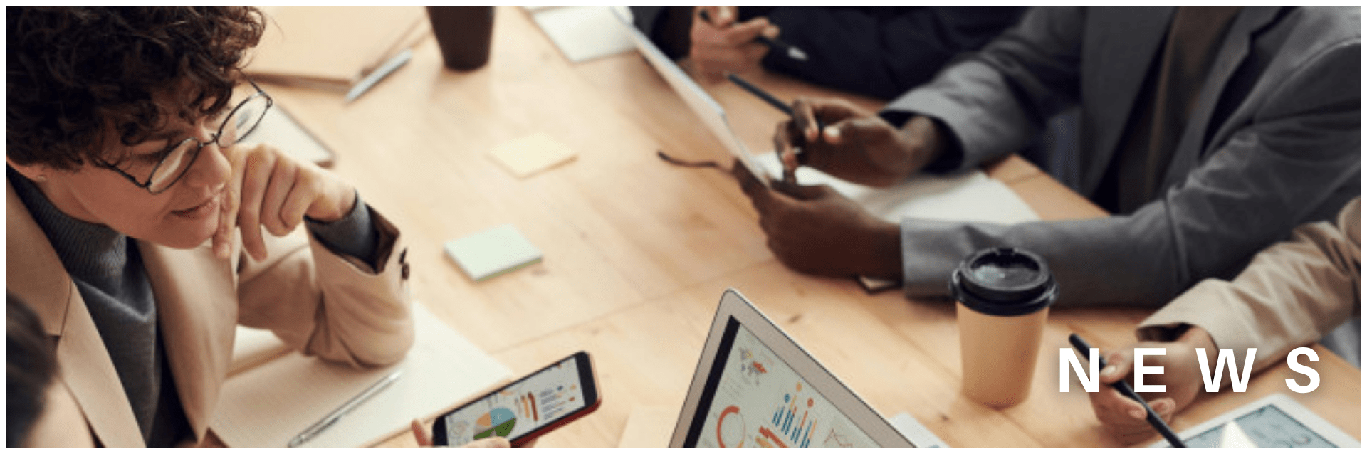 people around a table working with various computer devices