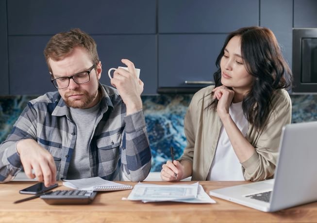 A couple looking worried while doing their budget