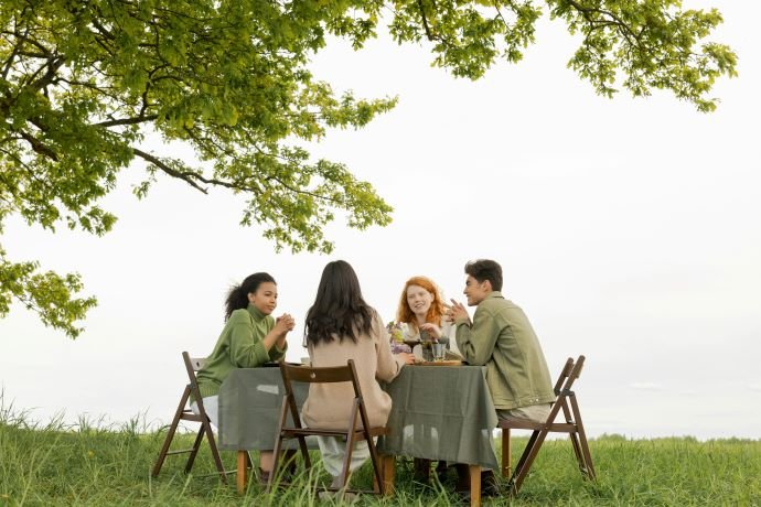 Young people around a table in a park, discussing