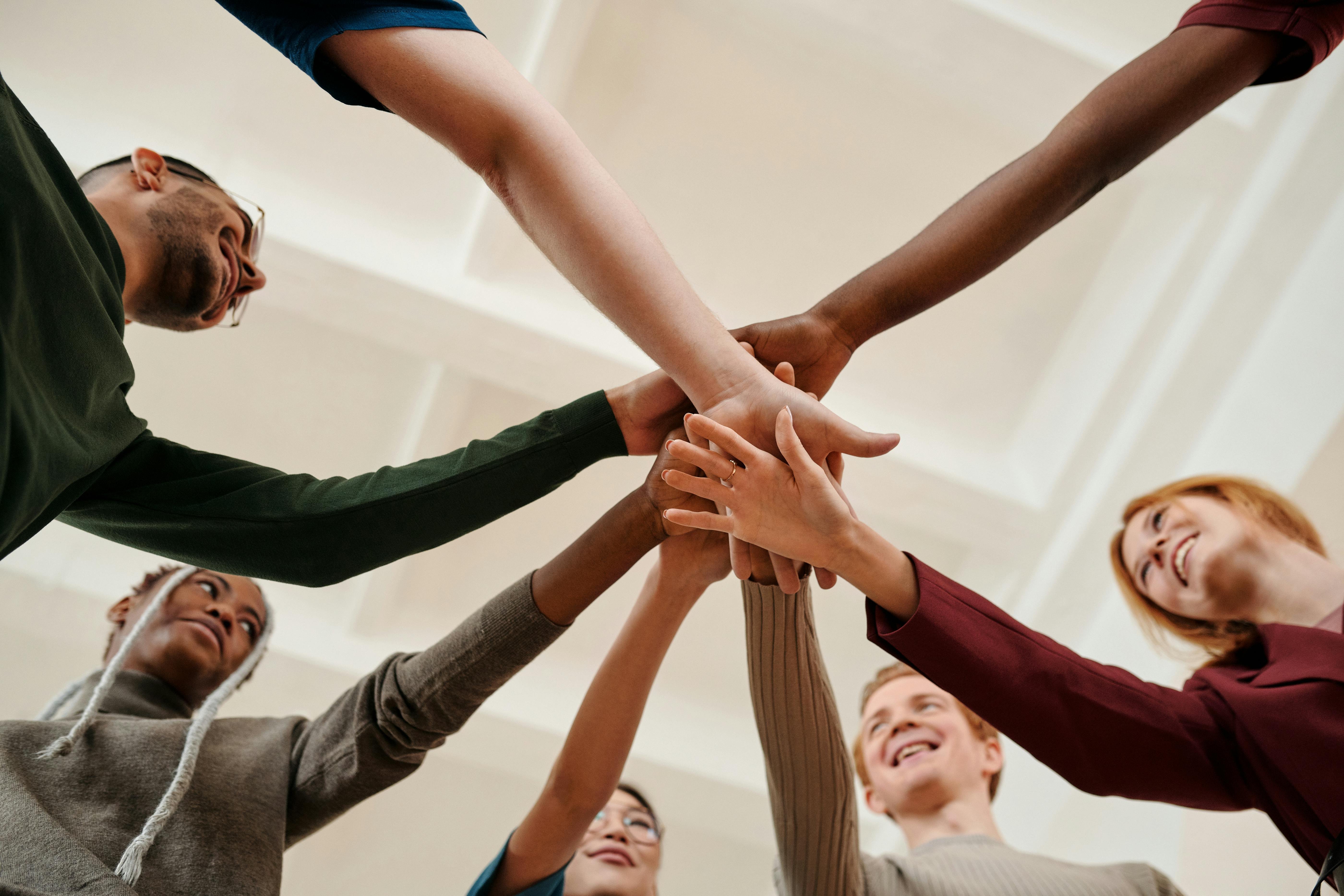 People putting their hands together in support